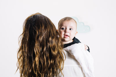 Frau von hinten mit Baby auf dem Arm
