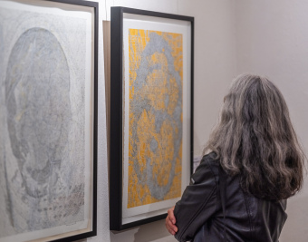 Eine Person vor einer Wand in der Ausstellung mit zwei hochformatigen Zeichnungen Dieter Appelts