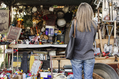 Eine Frau steht vor einem Flohmarktstand