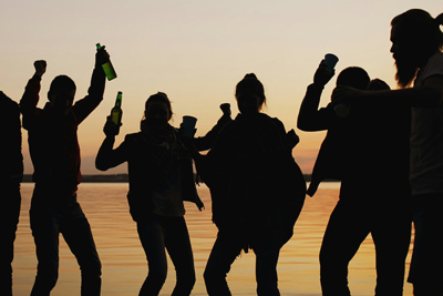 Menschen die mit Alkohol am Strand feiern 